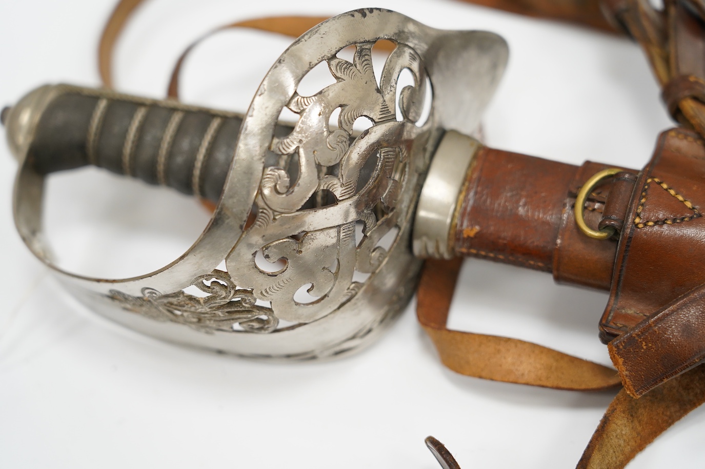An 1895 pattern infantry officer’s sword by Wilkinson, proof number 34431, blade 82cm, in it’s leather field service scabbard with hangers and sword knot, with supporting research confirming that it was purchased by the